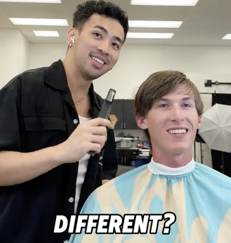 barber and young man sitting in a barber's chair